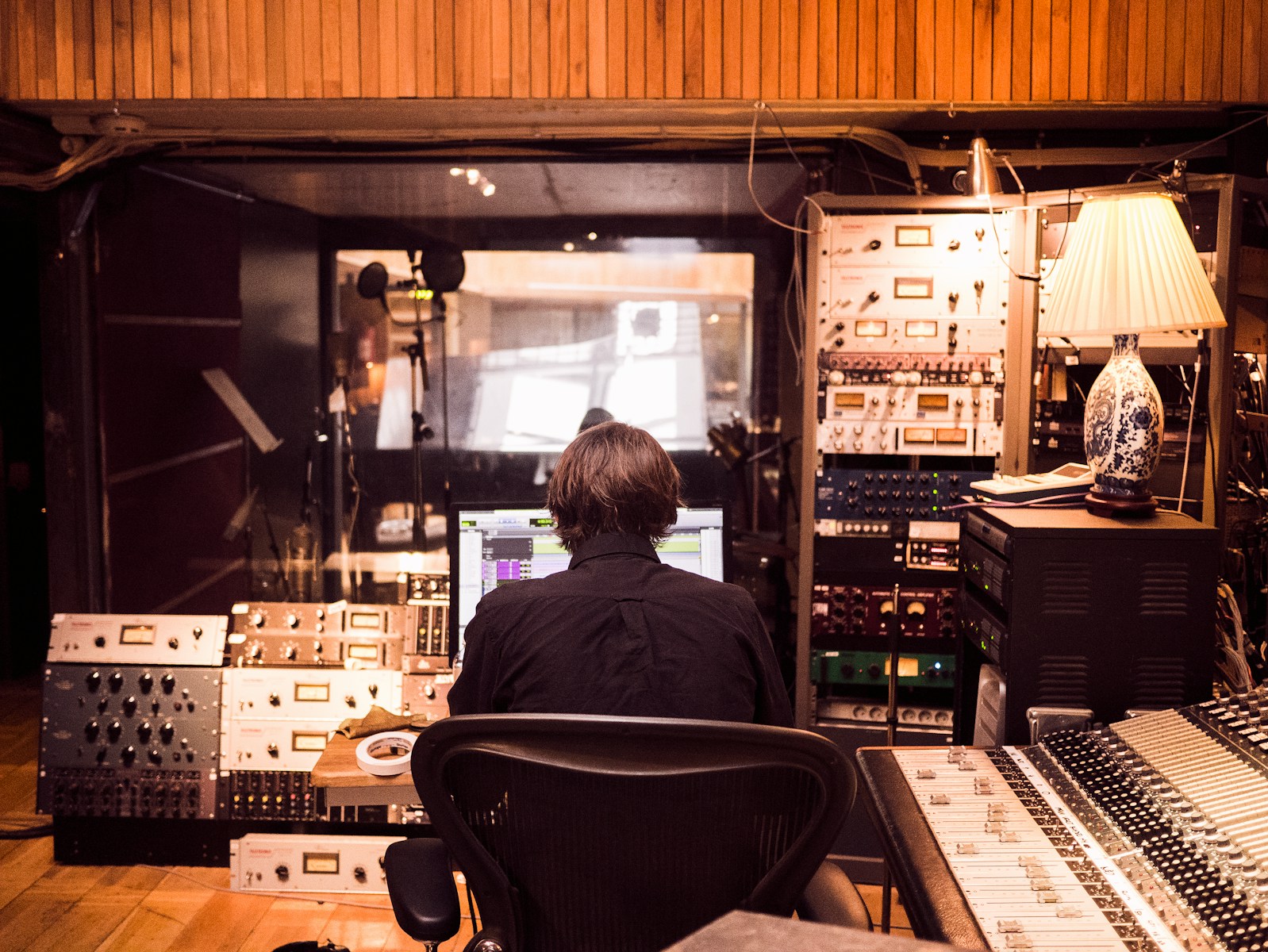 man in a recording studio front of studio mixer and receiver